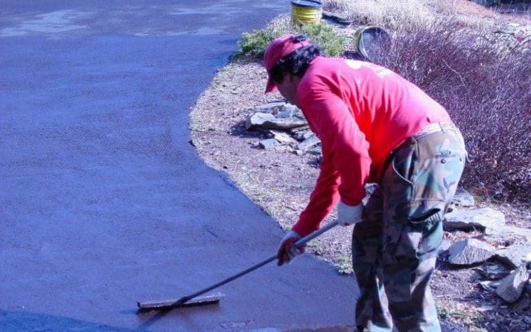 SAB employee spreading tar on a driveway