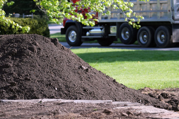 A Pile of top soil that has just been delivered as the delivery truck drives off